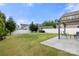 This backyard features a large grassy lawn with white vinyl fence, concrete patio, and a pergola with seating at 1221 Brookcrest Ln, Fort Mill, SC 29708