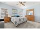 Spacious bedroom featuring light walls, carpet floors, natural light, wooden furniture, and modern decor at 1221 Brookcrest Ln, Fort Mill, SC 29708
