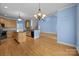 Spacious eat-in kitchen with hardwood floors, wooden cabinets, an island and modern light fixtures at 1607 Essex Hall Dr, Rock Hill, SC 29730