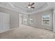 Spacious main bedroom featuring tray ceilings, neutral walls, large windows, and plush carpeting at 1607 Essex Hall Dr, Rock Hill, SC 29730