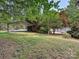 Lush backyard featuring mature trees, a covered parking area, and well-maintained grass at 208 Armstrong Dr, Belmont, NC 28012