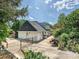 Charming white brick home featuring an attached garage, secure gated driveway and mature trees at 208 Armstrong Dr, Belmont, NC 28012