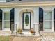 Close-up of a decorative front door with brick surround and flowering plants at 208 Armstrong Dr, Belmont, NC 28012