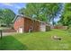 Brick home with a large backyard, fire pit, deck, detached garage, and mature trees at 2113 Woodlawn St, Kannapolis, NC 28083