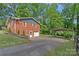 Image showing a red brick house, shed, green trees, and long driveway at 2113 Woodlawn St, Kannapolis, NC 28083