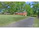 Spacious home with a long driveway, lush lawn, and mature trees, offering a serene setting at 2113 Woodlawn St, Kannapolis, NC 28083