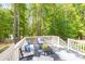 Inviting back deck with white railings and comfortable seating surrounded by lush trees at 212 Seven Oaks Lndg, Belmont, NC 28012