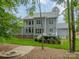 A serene backyard featuring mature trees, a fire pit, and a view of the home's deck at 212 Seven Oaks Lndg, Belmont, NC 28012