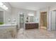 Luxurious bathroom with dual vanities, a glass-enclosed shower, and travertine tile flooring at 212 Seven Oaks Lndg, Belmont, NC 28012