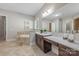 Elegant bathroom with a soaking tub, dual vanities, a built-in make-up counter, and travertine flooring at 212 Seven Oaks Lndg, Belmont, NC 28012