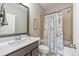 Neutral bathroom with dark wood cabinets, light countertop and shower/bath combination with unique curtain design at 212 Seven Oaks Lndg, Belmont, NC 28012