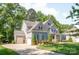 Side exterior view of a home, showcasing a three car garage, a well-kept lawn, and lush landscaping at 212 Seven Oaks Lndg, Belmont, NC 28012