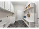 Well-organized mudroom with built-in shelving, a bench, hooks, and contrasting black tile flooring at 212 Seven Oaks Lndg, Belmont, NC 28012