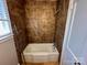 Bathroom featuring a tub with tiled surround and a window at 2434 Columbus Cir, Charlotte, NC 28208