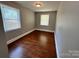 Bedroom with two windows, grey walls, hardwood floors and a ceiling light at 2434 Columbus Cir, Charlotte, NC 28208