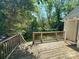 Wooden deck overlooks the backyard with stairs leading down, enhanced by summer foliage at 2434 Columbus Cir, Charlotte, NC 28208