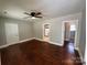 Open living room features hardwood floors, neutral walls, and a ceiling fan light fixture at 2434 Columbus Cir, Charlotte, NC 28208