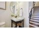 Charming powder room featuring a pedestal sink with decorative fixtures and a view of the staircase at 258 Iverson Way, Charlotte, NC 28203
