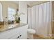 The bathroom features granite countertops, a decorative shower curtain, and offers a blend of style and functionality at 258 Iverson Way, Charlotte, NC 28203