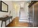 Inviting entryway with hardwood floors, stairs, console table, and decorative mirror at 258 Iverson Way, Charlotte, NC 28203