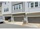 Exterior shot of townhome garages, showcasing neutral color scheme, functional space, and exterior AC units at 258 Iverson Way, Charlotte, NC 28203