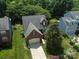 Aerial view of a brick and siding home with a mature tree canopy, and a two car garage at 2825 Redfield Dr, Charlotte, NC 28270