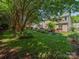 Well-maintained backyard featuring a lush lawn, mature trees, and colorful landscaping near the deck at 2825 Redfield Dr, Charlotte, NC 28270
