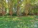 Private backyard showcasing a green lawn framed by crape myrtle trees and a wooden fence at 2825 Redfield Dr, Charlotte, NC 28270