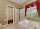 Bright bathroom with large bathtub and shower stall, bathed in light from a nearby window at 2825 Redfield Dr, Charlotte, NC 28270