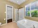 Bright bathroom with large bathtub and shower stall, bathed in light from a nearby window at 2825 Redfield Dr, Charlotte, NC 28270