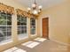 Bright dining area with three windows and chandelier, creating a welcoming space for meals and gatherings at 2825 Redfield Dr, Charlotte, NC 28270