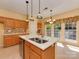 Well-lit kitchen island with a stainless steel sink, modern backsplash, and wood cabinets at 2825 Redfield Dr, Charlotte, NC 28270