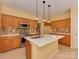 Bright kitchen with stainless appliances, white countertops, tile backsplash, and wood cabinets at 2825 Redfield Dr, Charlotte, NC 28270
