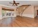 Large living room featuring hardwood floors, a ceiling fan, and views of the entry and staircase at 2825 Redfield Dr, Charlotte, NC 28270