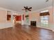 Bright living room featuring hardwood floors, fireplace, ceiling fan, and neutral wall paint at 2825 Redfield Dr, Charlotte, NC 28270