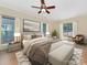 Staged main bedroom featuring a king bed, neutral palette, and an abundance of natural light through multiple windows at 2825 Redfield Dr, Charlotte, NC 28270
