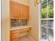Compact office nook features oak cabinets, granite countertop, and backsplash, bathed in light from a nearby window at 2825 Redfield Dr, Charlotte, NC 28270