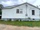 The backyard of the home featuring peeling paint and an overgrown yard in need of remodeling at 302 Melrose Sw Dr, Concord, NC 28025