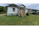 The front exterior of the home featuring peeling paint, overgrown yard, and a porch in need of remodeling at 302 Melrose Sw Dr, Concord, NC 28025