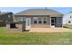 Cozy backyard area with stone patio, brick fireplace, lush green grass and view of a sunroom at 3073 Oliver Stanley Trl, Lancaster, SC 29720