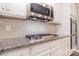 Close-up of a kitchen with a cooktop, subway tile backsplash, and stainless steel appliances at 3073 Oliver Stanley Trl, Lancaster, SC 29720