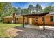 View of brick back exterior with covered patio and a well-maintained lawn at 3116 Old Montgomery Place Rd, Monroe, NC 28112