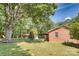 Expansive backyard featuring a lush lawn, mature trees, and a charming brick home with a covered porch at 3116 Old Montgomery Place Rd, Monroe, NC 28112