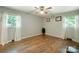 Bright bedroom featuring hardwood floors, neutral walls, ceiling fan, and two windows with natural light at 3116 Old Montgomery Place Rd, Monroe, NC 28112