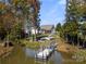 Scenic backyard view of a lake house with a private dock and tranquil water views surrounded by trees at 31226 Cove View Ct, Lancaster, SC 29720