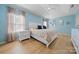 Light-filled primary bedroom features a tray ceiling, wood floors, and decorative mirrors at 31226 Cove View Ct, Lancaster, SC 29720