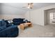Comfortable living room features a ceiling fan and a large blue sectional sofa with woven coffee table at 31226 Cove View Ct, Lancaster, SC 29720