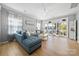 Bright living room featuring a comfortable blue sectional sofa, wood floors, and sliding doors to a screened porch at 31226 Cove View Ct, Lancaster, SC 29720