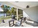 Screened in back porch with a view of the lake, with chairs and a grill at 31226 Cove View Ct, Lancaster, SC 29720