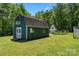Green barn with white accents situated near a garden and adjacent white shed in a backyard at 370 Shiloh Rd, Statesville, NC 28677